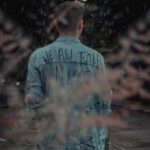 back view of a young man in a denim jacket