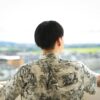 unrecognizable man standing on open balcony against green city