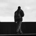 silhouette of person with backpack in urban setting